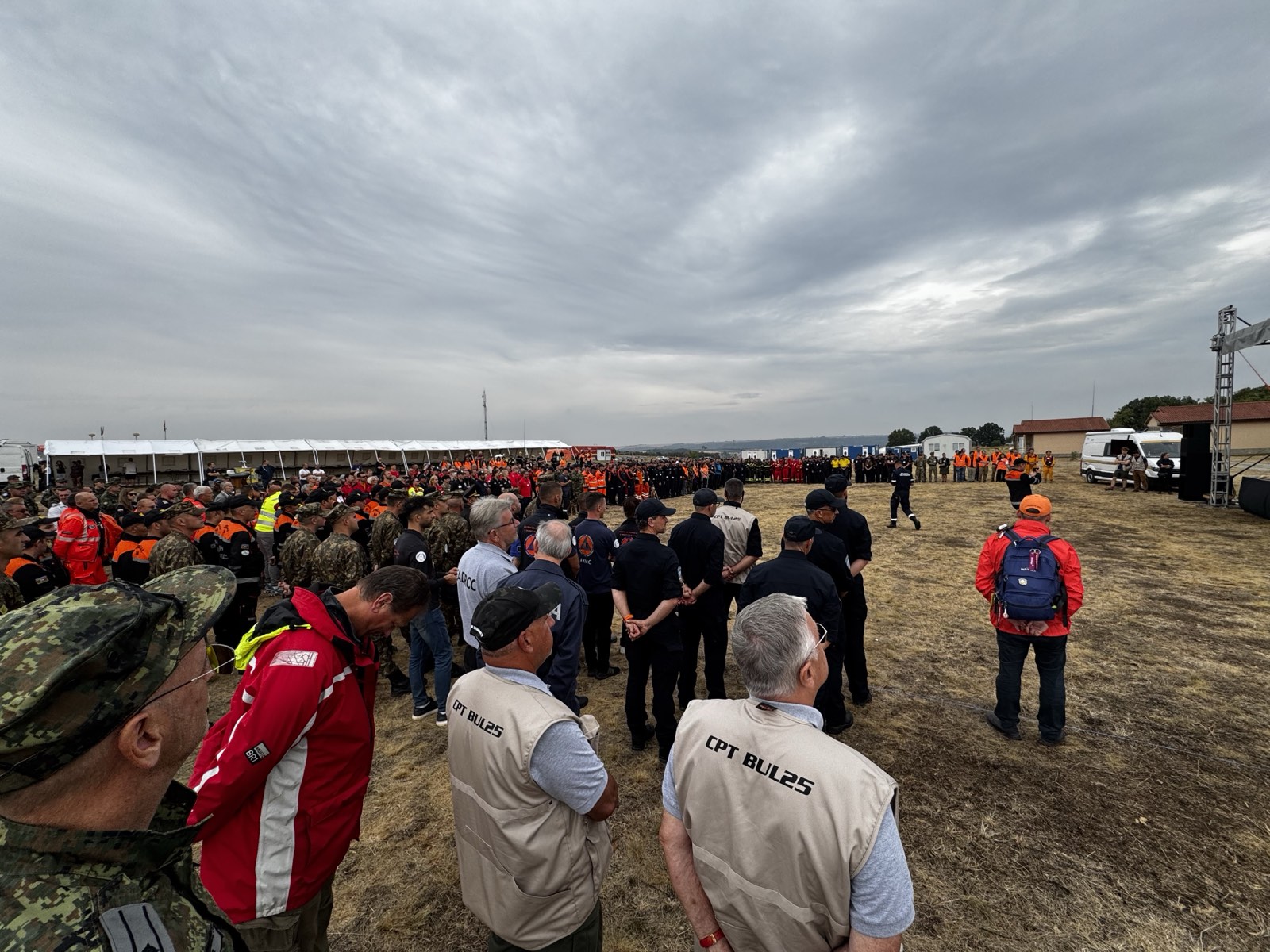 Multinational civil protection teams assembled on the BULGARIA 2025 field exercise grounds, with exercise tents and staging areas behind them